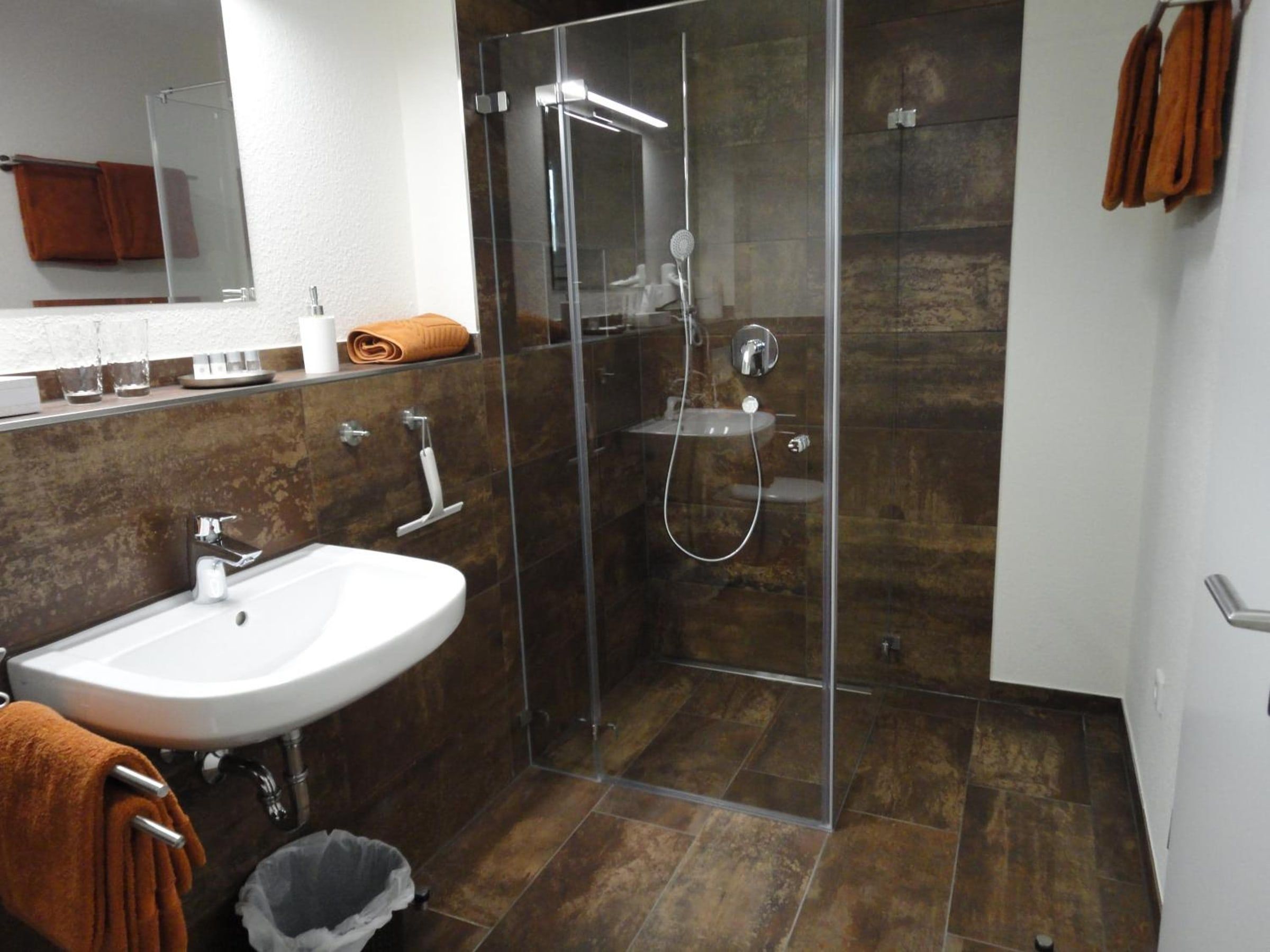 Bad mit bodengleicher Glasdusche und Waschbecken