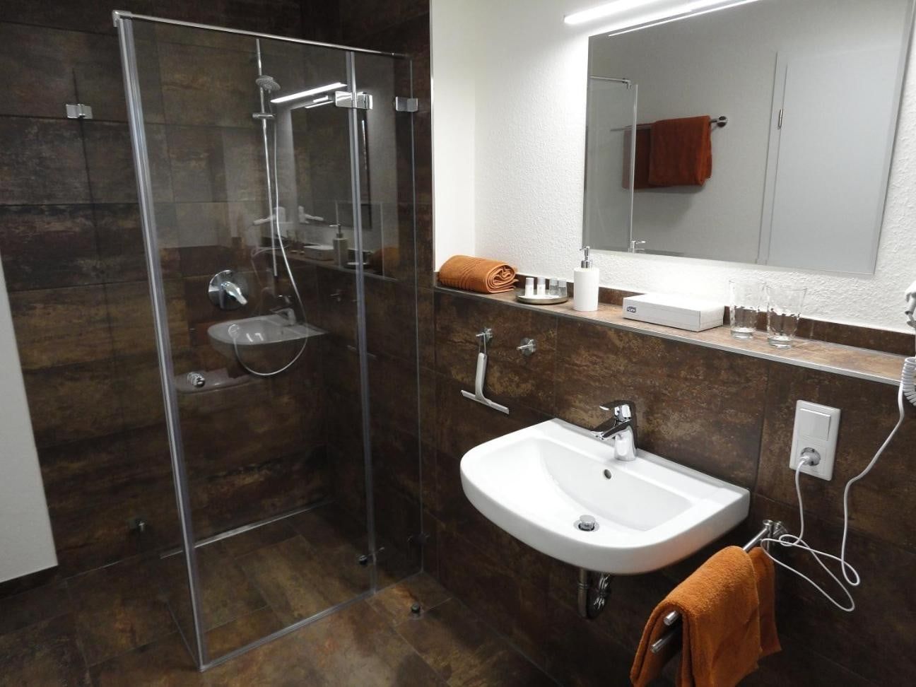 Bad mit bodengleicher Glasdusche und Waschbecken