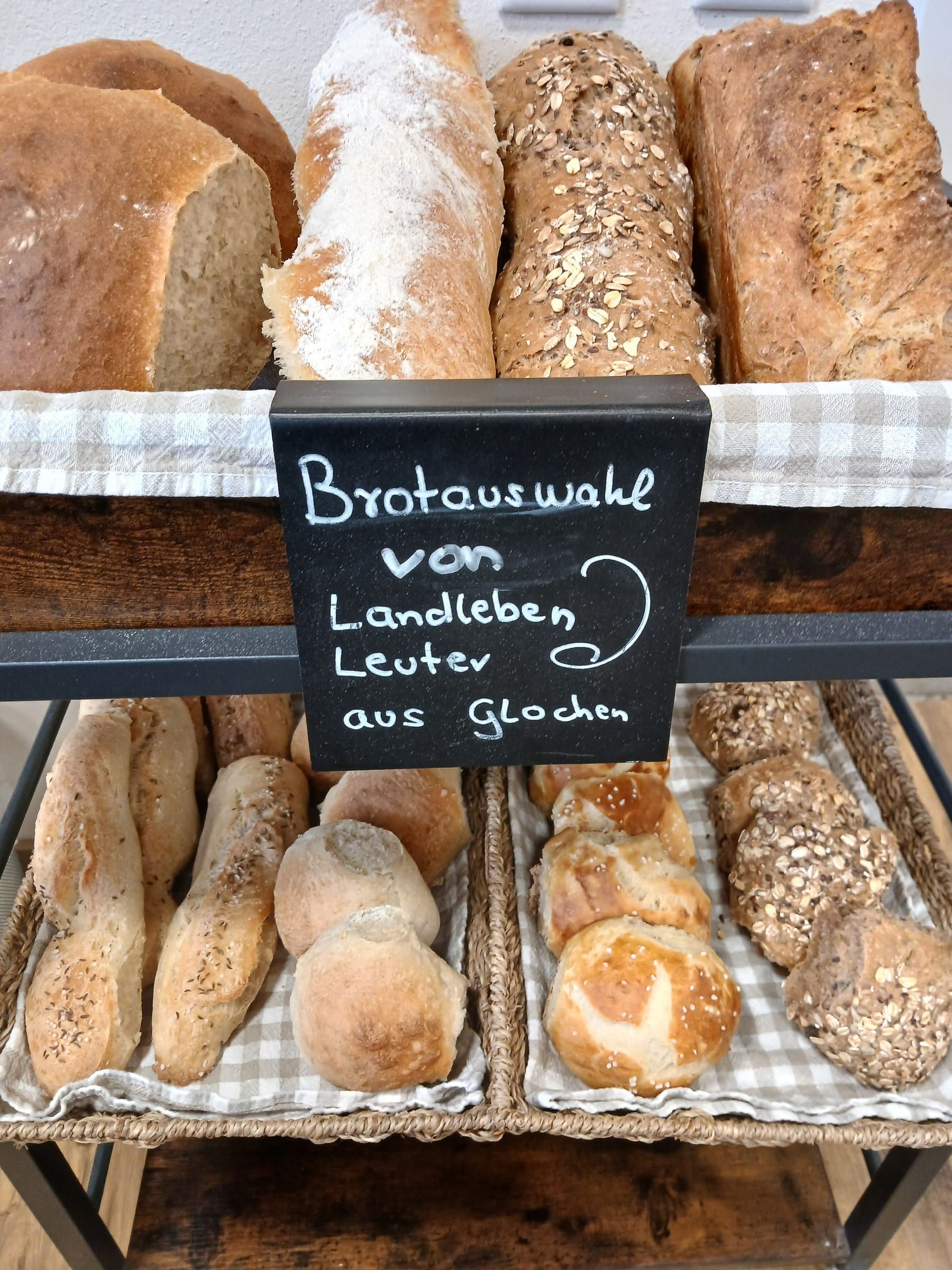 Regal mit Broten und Brötchen unter einer Kreidetafel