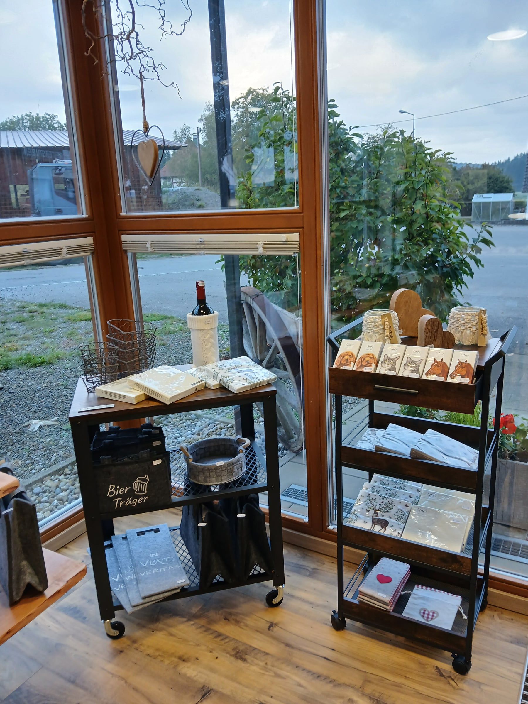 Regalwagen mit Servietten, Wein und Geschenkartikeln im Hofladen