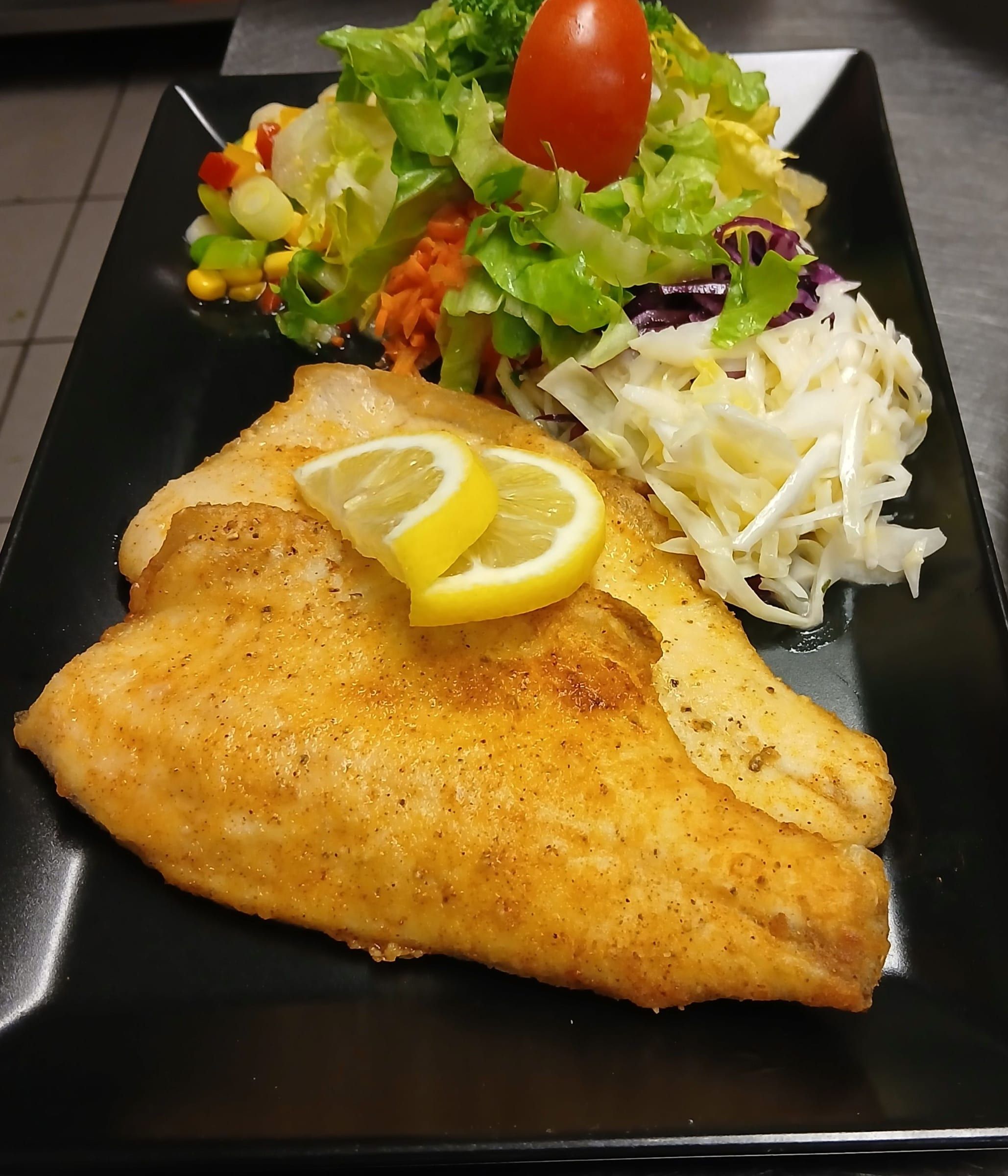 Gebratenes Fischfilet mit Zitrone und Salat