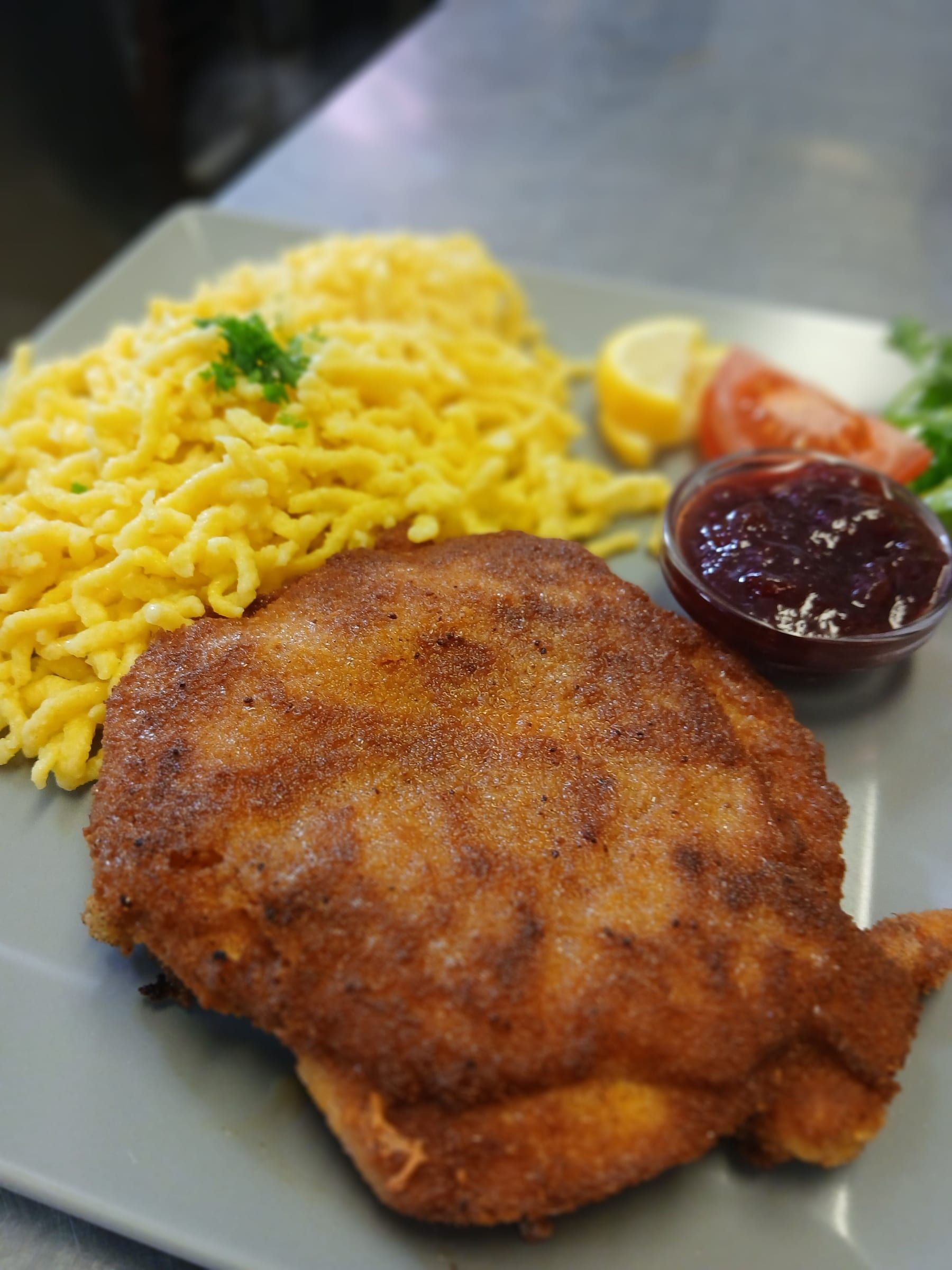 Paniertes Schnitzel mit Spätzle, Preiselbeeren und Salat