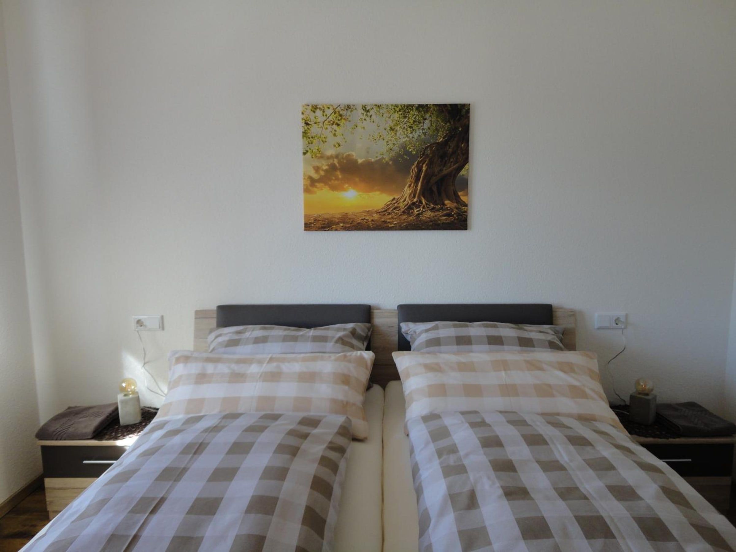 Doppelbett mit karierter Bettwäsche und Nachttischen