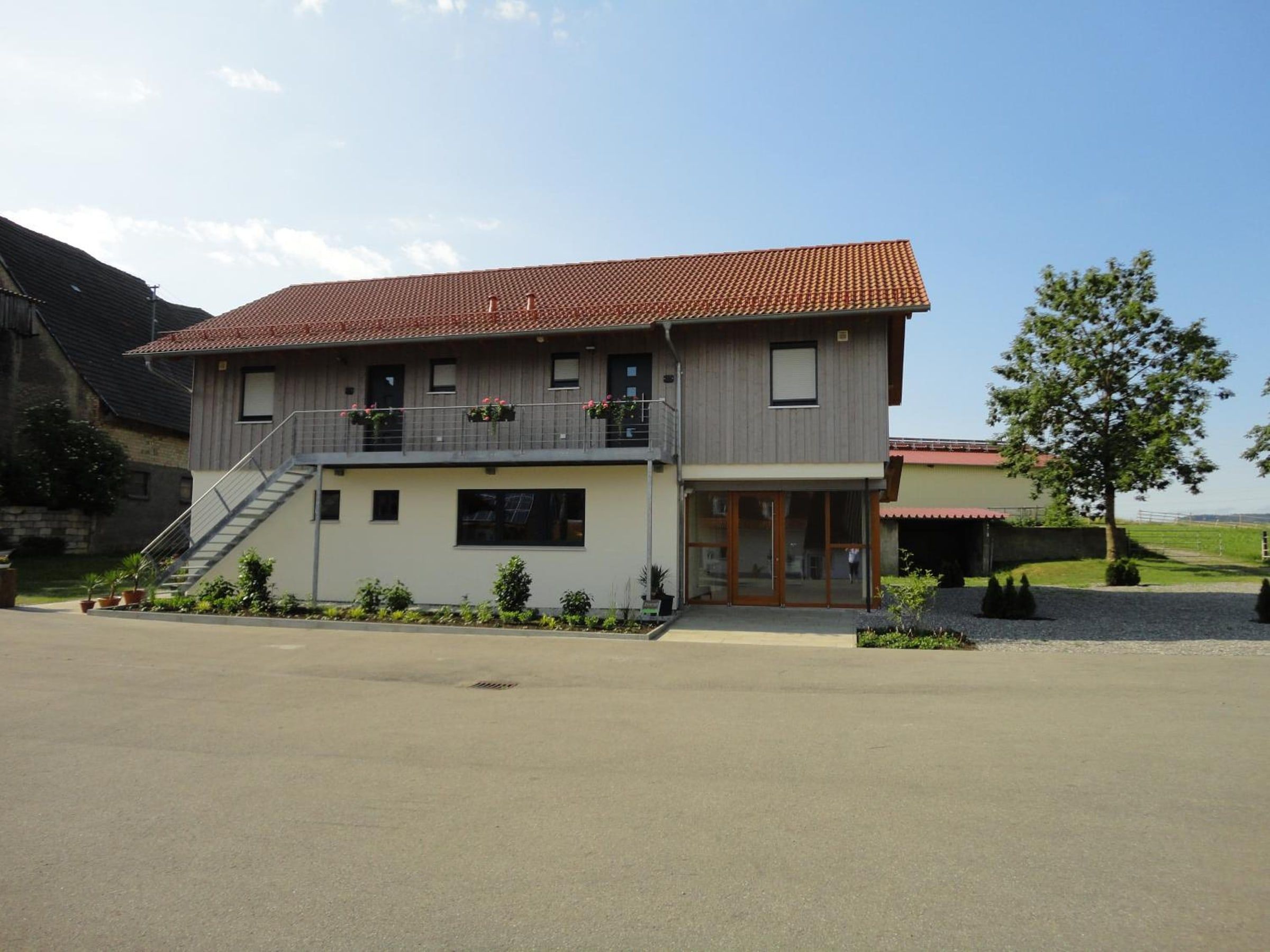 Gästehaus mit den Ferienwohnungen, Holzfassade und Außentreppe zum Obergeschoss